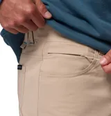 Pantalón beige de la colección ROC de Columbia, de corte recto y tejido elástico, con trabillas, bolsillos funcionales y detalle reflectante en los puños.