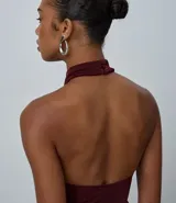Body de mujer con diseño halter, confeccionado en tejido rib acanalado con acabado brillante. Presenta cuello alto con cierre posterior, corte ajustado al cuerpo y diseño sin mangas.