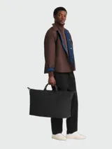 Bolso de viaje grande Longchamp modelo Le Pliage One, de diseño minimalista en color negro, con asas cortas y cierre superior.