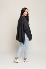 Poncho de lana merino color gris oscuro, con mangas largas ajustadas y cuerpo suelto.