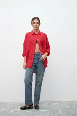 Camisa de lino color rojo, de corte oversize, con cuello clásico, cierre frontal de botones y bolsillo en el pecho.