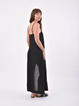 Vestido largo negro de lino con tirantes finos, escote recto y tajo lateral en la falda.