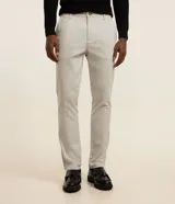 Pantalón slim de sastrería de color gris claro, confeccionado en sarga de algodón con elastano, con cierre frontal de botón y cremallera, y bolsillos.