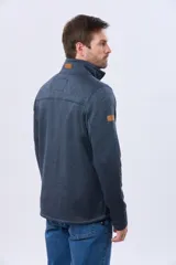 Campera de tejido texturado en color azul, con interior de polar, cuello alto, cierre frontal completo y bolsillo vertical en el pecho con detalle de tirador de cuero sintético.