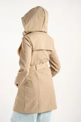 Trench impermeable de corte oversize en color camel, con diseño de doble botonadura, solapas clásicas y cinturón ajustable en la cintura.