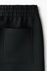 Pantalón tipo jogger de corte relajado con efecto neopreno, cintura elástica con cordón ajustable, bolsillos laterales al bies y bolsillo de parche en la parte trasera.
