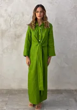 Vestido camisero largo color verde lima, con cuello camisero, mangas largas con puños abotonados, cierre frontal con botones y lazo anudado en la cintura.