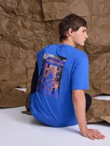 Remera de manga corta color azul con estampa artística en la espalda que representa una fachada de edificio con sombras.
