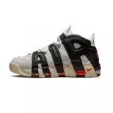 Championes Nike Air More Uptempo 96 de color blanco, negro y gris, con detalles en naranja y rojo. Presentan el característico diseño con las letras "AIR" sobredimensionadas en los laterales, suela de goma con amortiguación visible y un estilo urbano robusto.