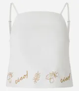 Blusa confeccionada en sarga de algodón, de color blanco, con escote cuadrado y tirantes finos. Presenta un detalle bordado en la parte inferior con motivos botánicos y la palabra ciao.