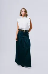 Blusa sin mangas color blanco con cuello alto con volados y detalles de volados en los hombros. Cuenta con cierre frontal de botones.