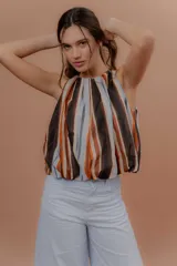 Musculosa de algodón con cuello redondo, sin mangas y diseño abullonado en la parte inferior. Estampado a rayas verticales en tonos celeste, marrón, naranja y blanco.