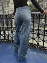 Jean de corte recto y tiro medio, color azul lavado, con estampado de alas de ángel en la parte trasera.