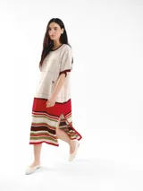 Vestido largo de punto con detalles calados, escote redondo, mangas cortas y diseño de rayas en la parte inferior. Cuenta con aberturas laterales en el dobladillo.
