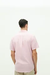 Camisa de manga corta confeccionada en una mezcla de lino y algodón, con cuello clásico, cierre frontal de botones y bolsillo en el pecho con logo bordado.