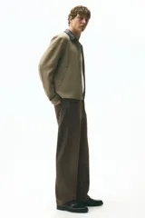 Jeans de cinco bolsillos en denim de algodón rígido, color marrón oscuro con efecto lavado. Modelo de cintura estándar con cierre y corte relajado, pierna recta y amplia desde el muslo.