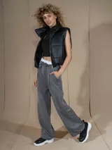 Pantalón de vestir ancho (wide leg) color gris oscuro, con cintura alta ajustable con lazo blanco y pliegues frontales.