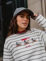 Buzo de cuello redondo con diseño a rayas horizontales grises sobre fondo crudo. Presenta un estampado frontal con la inscripción 'RUNNING club' y 'EST. 1928' junto a ilustraciones de Mickey Mouse en movimiento.