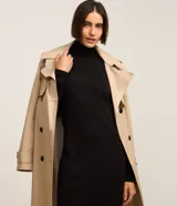 Vestido de punto negro, de manga larga y cuello alto, con corte recto y largo midi.