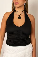 Top halter negro con fruncido central y escote pronunciado.