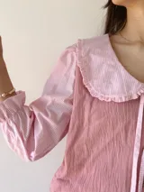 Camisa rosa con mangas 3/4 a rayas y cuello babero con volados.
