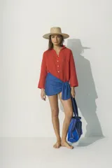 Camisa blanca de lino con cuello clásico, manga larga con puños abotonados y cierre frontal con botones. Corte recto y holgado.