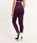 Calza deportiva color violeta con cintura alta y detalle texturizado en la parte trasera. Presenta un pequeño bolsillo funcional. Confeccionada en poliamida y elastano.