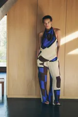 Top de cuello halter con hombros descubiertos, espalda descubierta, detalle de drapeado lateral y bajo asimétrico.