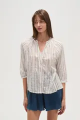 Camisa de algodón con diseño de rayas verticales y detalles bordados. Presenta cuello en V, cierre frontal con botones y mangas tres cuartos con terminación elástica.