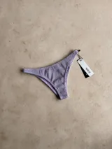 Bombacha de bikini vedetina con estampado geométrico en tonos naranja, celeste y rosa.