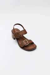Sandalias de taco cuadrado en color whisky, con tiras decoradas con tachas y hebillas metálicas en tono bronce, y tira ajustable en el talón.