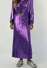 Conjunto plateado brillante de top con breteles finos y pollera larga con efecto mojado.