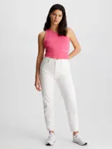 Top cropped de punto milano color rosa vibrante, con diseño asimétrico de un solo hombro y corte ajustado (slim fit). Presenta un pequeño bordado de Calvin Klein Jeans en la cintura.