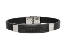 Pulsera de cuerina negra con apliques de acero plateado y cierre de hebilla. Presenta un aplique central de acero negro con diseño de guarda griega.