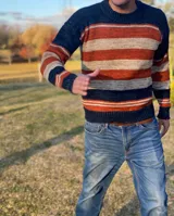 Sweater de lana merino a rayas horizontales en tonos azul marino, naranja y gris.