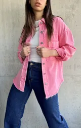 Sobrecamisa rosa de denim con terminaciones desflecadas, cuello camisero, cierre frontal con botones metálicos, dos bolsillos de parche en el pecho y mangas largas con puños abotonados.