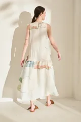 Vestido midi sin mangas de lino, con diseño estampado tipo paisaje en tonos rosado, verde militar y beige, corte recto y falda con volados en la parte inferior.