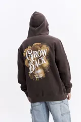 Canguro con capucha de algodón color celeste, con estampa gráfica en la espalda que incluye flores y la frase 'Grow Back'. Presenta un parche pequeño en la manga y corte regular.