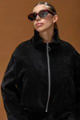 Campera tipo bomber de textura aterciopelada, con cuello alto estructurado y cierre frontal con cremallera metálica.