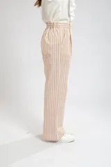 Pantalón de vestir de tiro alto, color beige con rayas verticales blancas, corte palazzo.