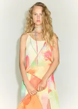 Vestido midi de tejido fluido con estampado floral en tonos pasteles, escote en pico y tirantes finos. Presenta un diseño asimétrico con tajo lateral.