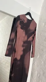 Vestido midi marrón con estampado abstracto en negro, de corte ajustado y manga larga.