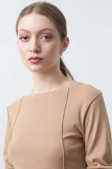 Remera de manga larga color blanco, de calce entallado, con cuello redondo a la base y costuras verticales decorativas que estilizan la silueta.