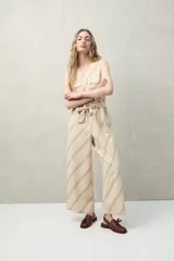 Mono largo sin mangas de algodón con estampado de hojas en tonos verde y beige. Tiene cuello en V, cierre frontal con botones, bolsillos laterales y cinturón de lazo.