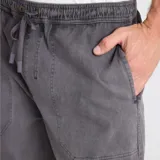 Pantalón de corte relajado color gris con efecto desgastado, confeccionado en tejido Bedford elástico. Cuenta con cintura elástica con cordón ajustable y bolsillos frontales tipo parche.