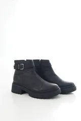 Botinetas de cuero negro con suela track y taco bajo. Presentan una correa decorativa con hebilla metálica alrededor del tobillo y cierre lateral interno.