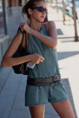 Mono corto de denim con cuello halter, espalda descubierta y costuras marcadas.