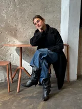 Botas de cuero negro de caña media con diseño fruncido tipo slouchy, punta fina y taco bajo.
