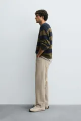 Pantalón de corte recto confeccionado en tejido de algodón con elasticidad. Presenta diseño de cinco bolsillos, cierre frontal con cremallera y botón.