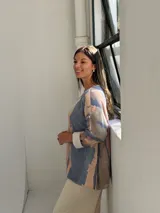 Sweater de tejido de punto con diseño abstracto en tonos azul, beige y rosado, de corte holgado y mangas largas con puños vueltos.